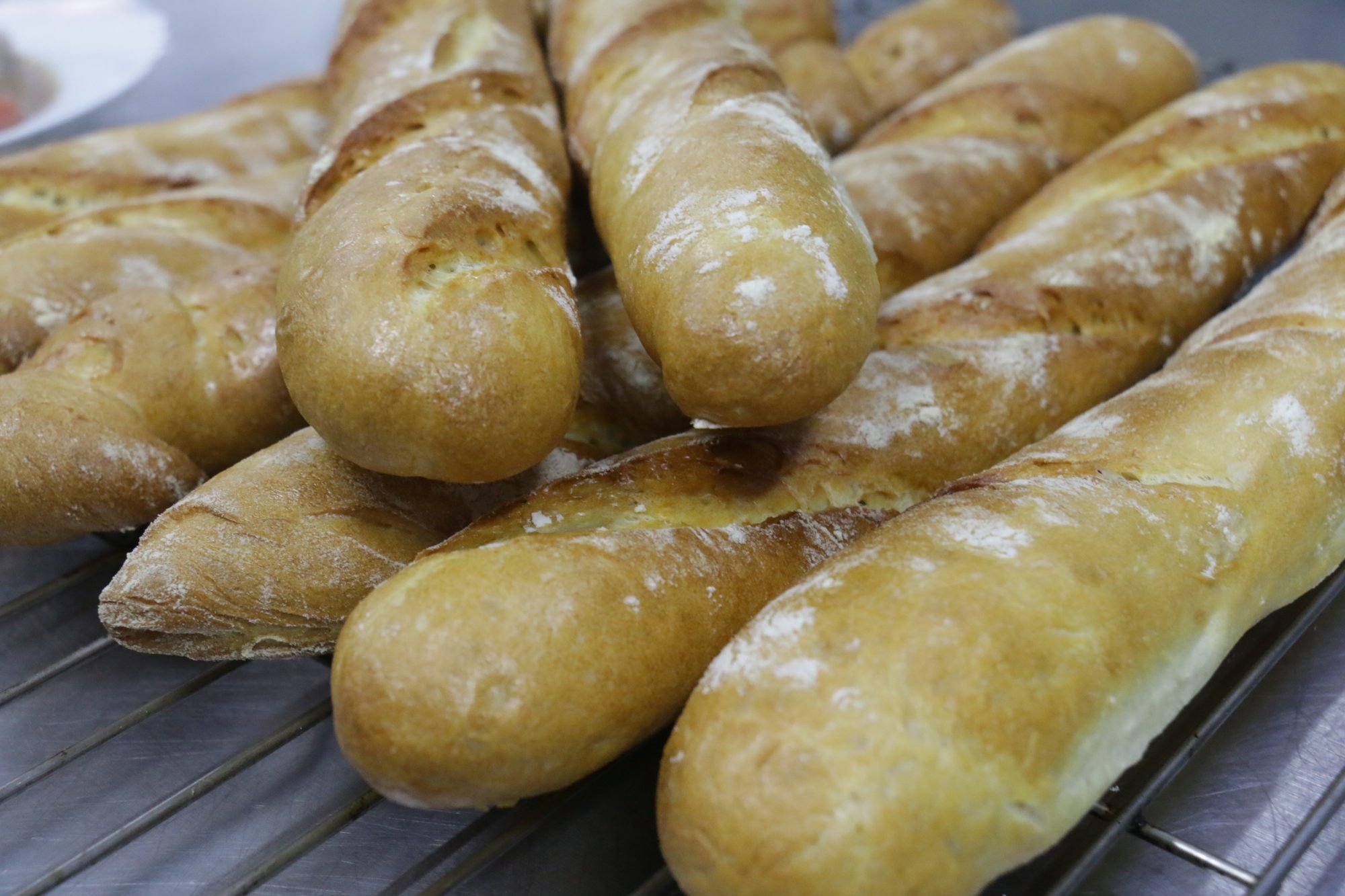 Baguettes dusted with flour on a cooling rack