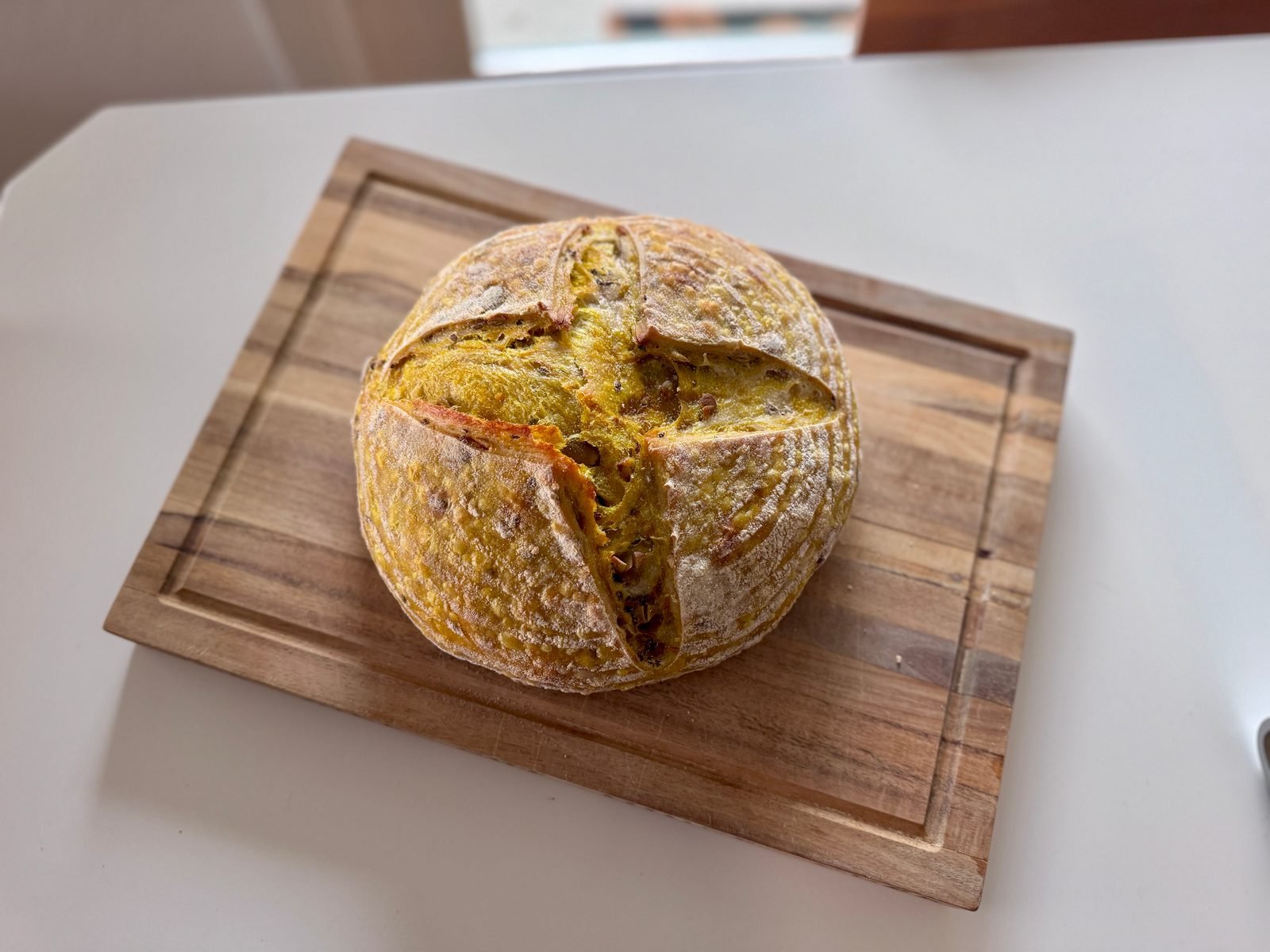 A round seeded loaf on a wooden board